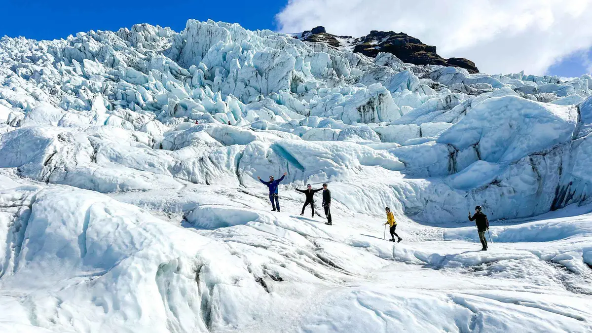 Hikers descending between deep crevasses on a five-hour half-day Skaftafell glacier hike in Vatnajökull National Park, Iceland